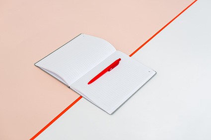 Biały notes z czerwonym długopisem na otwartej stronie