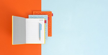 Otwarty notes z metką na okładce i kolorowymi przekładkami