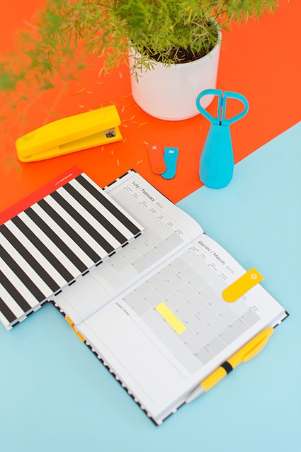 Otwarty notes z magnesami, karteczkami i żółtym długopisem