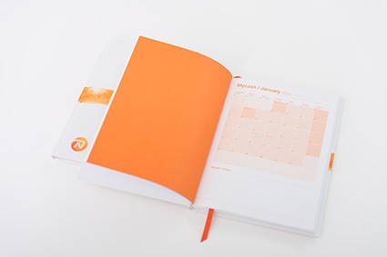 Otwarty notes z pomarańczową wkładką reklamową