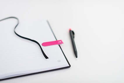 Notes z czarną tasiemką, różową zakładką i długopisem