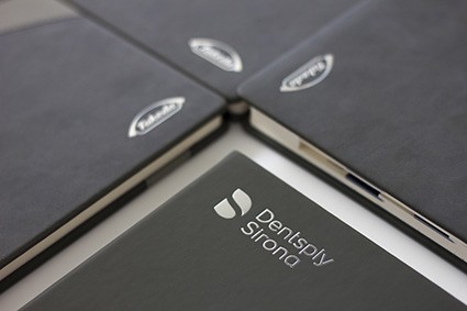Czarne notesy z metalowymi blaszkami na okładkach