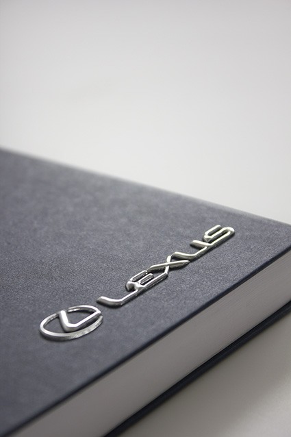 Czarny notes z metalową blaszką Lexus na okładce